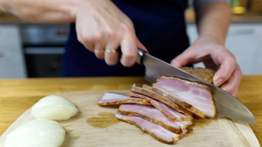 Aşçı ahşap tahtada pastırma keser.