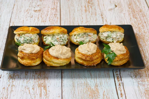 Bir tabakta salata ile doldurulmuş börek dolu aperatif.