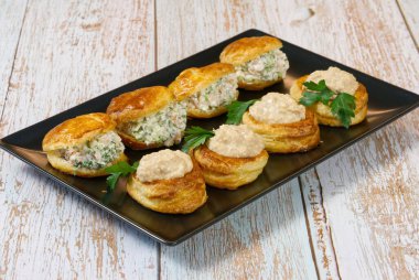 Bir tabakta salata ile doldurulmuş börek dolu aperatif.