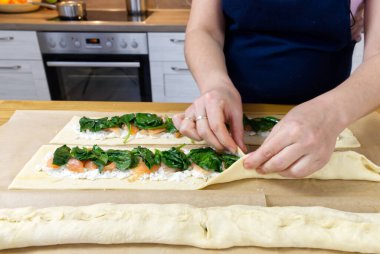 Aşçı hamura ıspanak ve alabalık koyar. Çelenk pişirme işlemi şeklinde lezzetli bir Noel turtası.