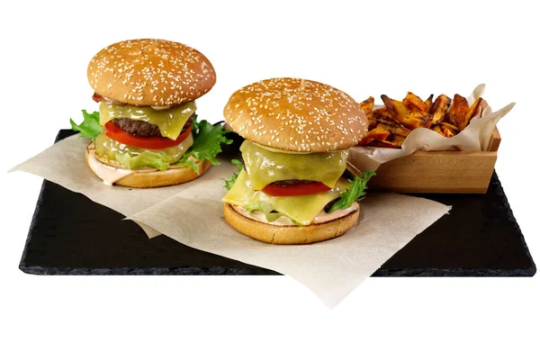 İki büyük burger ve siyah taş tabakta izole edilmiş tatlı patates. beyaz arkaplan