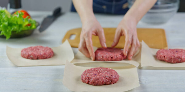 Womans hand forming a beef meat for a hamburger party. Portioning ground meat. Homemade burgers. Making food at home.
