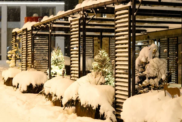 Straßencafé im Winter. Sitzgelegenheiten und Tische unter dem Schnee. Winter auf der Straße. Kein Volk. — Stockfoto