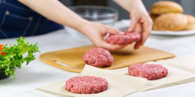 Hamburger partisi için et yapan kadın eli. Kıyma porsiyonu. Ev yapımı hamburgerler. Evde yemek yapmak..