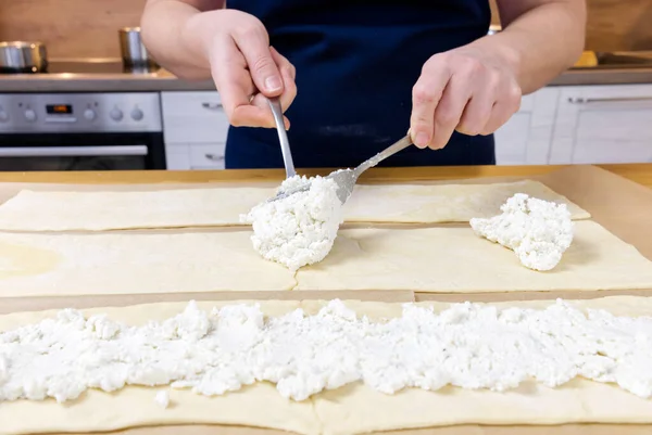 El chef pone queso cottage en la masa. Pastel de Navidad salado en la forma de un proceso de fabricación de la corona. —  Fotos de Stock