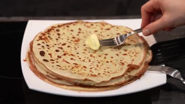 Pancakes on a plate and grease with butter. Big pancake. Cooking smoke goes up from pancake. Big pancakes with holes. Pancake weekend. Russian tradition. — Stock Video