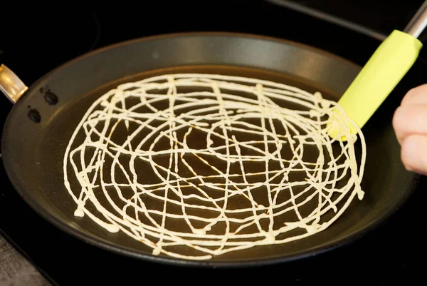 Evde ağ şeklinde krep pişirmek. Alışılmadık sokak yemekleri. Roti Jala Malezya yemeği.