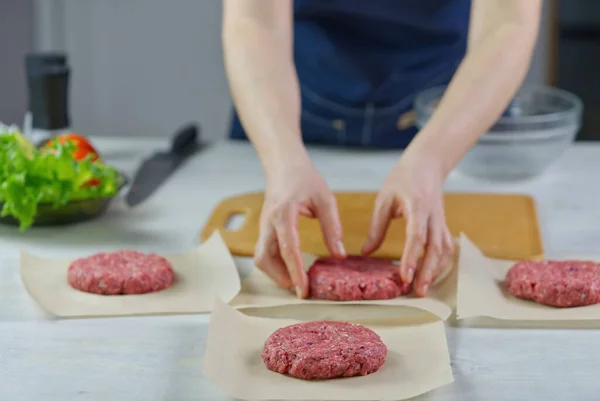 Hamburger partisi için et yapan kadın eli. Kıyma porsiyonu. Ev yapımı hamburgerler. Evde yemek yapmak..