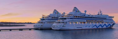Tallinn, Estonya -05 Mart 2022: Günbatımında limanda AIDA Cruise gemisi. Harika bir akşam vakti AIDA lüks yolcu gemisi. Çok renkli gökyüzü.