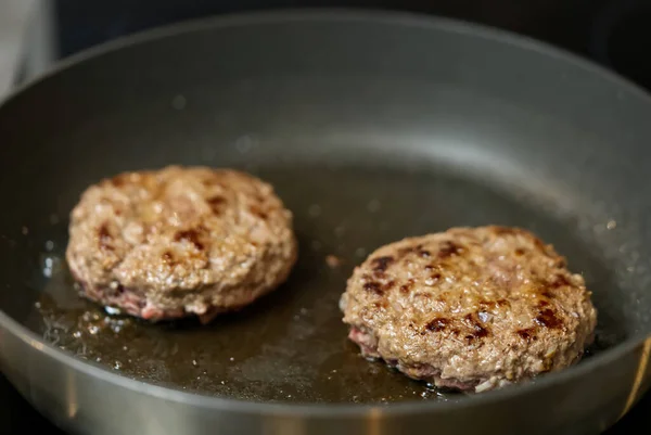 Hamburger meat grilling for burgers. Homemade cutlets in frying pan — Stock Photo, Image