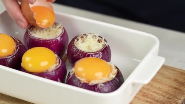 Kocken lägger ett rått ägg på en lök fylld med malet kött och grönsaker. — Stockvideo