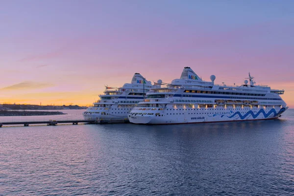 Tallinn, Estonya -05 Mart 2022: Günbatımında limanda AIDA Cruise gemisi. Harika bir akşam vakti AIDA lüks yolcu gemisi. Çok renkli gökyüzü.
