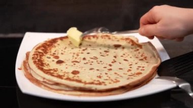 Tabakta krep ve tereyağlı yağ. Büyük krep. Krepten duman çıkıyor. Delikli büyük gözlemeler. Krep hafta sonu. Rus geleneği.