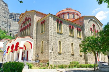 Küçük Kalampaka kasabasındaki ana Rum Ortodoks kilisesi. Yunanistan Meteora dağ vadisinde yaz bulutlu bir gün. Kapat.