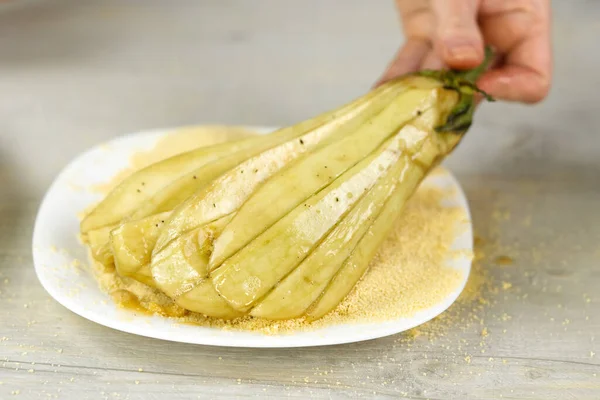Ekmek kırıntılarıyla dilimlenmiş patlıcan. Kadın evde lezzetli çerezler pişiriyor. Kapat.