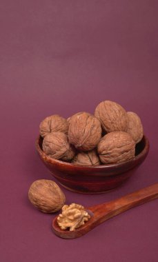 Eflatun arka planda tahta kaşıkla ceviz yığını 