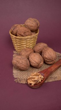 Eflatun arka planda tahta kaşıkla ceviz yığını 