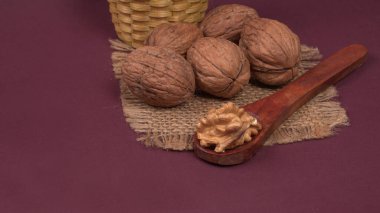 Eflatun arka planda tahta kaşıkla ceviz yığını 