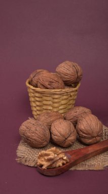 Eflatun arka planda tahta kaşıkla ceviz yığını 