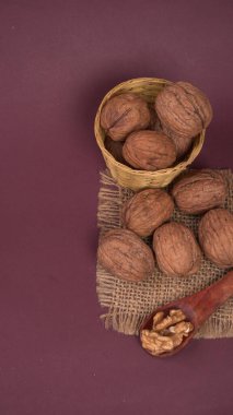 Eflatun arka planda tahta kaşıkla ceviz yığını 