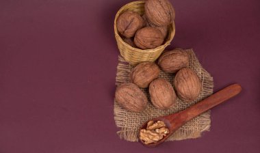 Eflatun arka planda tahta kaşıkla ceviz yığını 