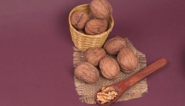 Eflatun arka planda tahta kaşıkla ceviz yığını 