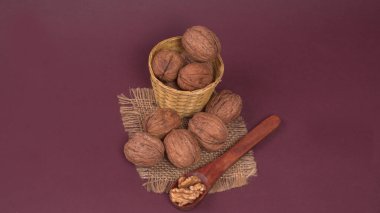 Eflatun arka planda tahta kaşıkla ceviz yığını 