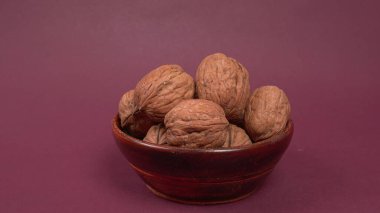 Mor arkaplanda ceviz yığını, yakın çekim. 