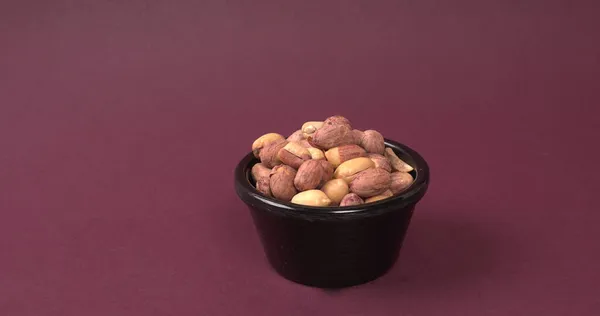 Schüssel Erdnüsse Auf Violettem Hintergrund — Stockfoto