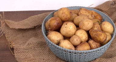 Tahta masada pişirmek için taze patates.