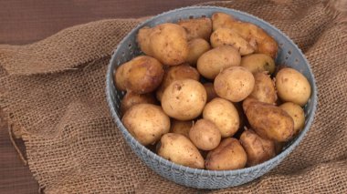Tahta masada pişirmek için taze patates.