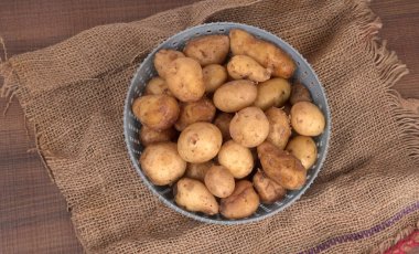 Tahta masada pişirmek için taze patates.