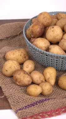 Tahta masada pişirmek için taze patates.