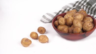 Beyaz arka planda ahşap kasede pişirmek için taze patatesler. 