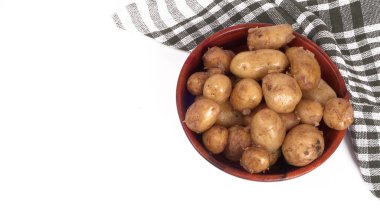 Beyaz arka planda ahşap kasede pişirmek için taze patatesler. 