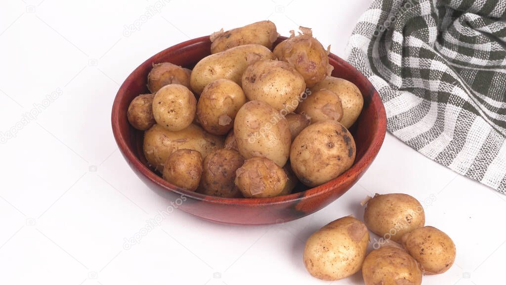 Fresh small potatoes for cooking in wooden bowl on white background 