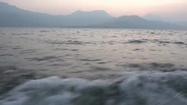 Denizdeki gemiden POV, küçük adanın üstünde günbatımı gökyüzü 