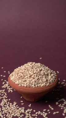 Mor arkaplanda bir kase beyaz fasulye. 