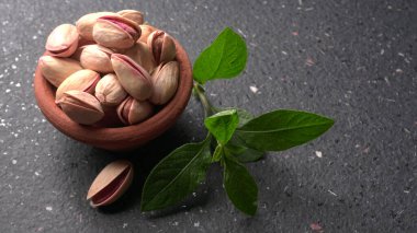 Yeşil yapraklarla süslenmiş fıstıklar veya fındıklar.