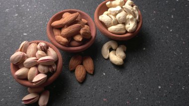 Stüdyo arka planında yeşil yapraklı çeşitli fındıklar.