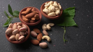 Stüdyo arka planında yeşil yapraklı çeşitli fındıklar.