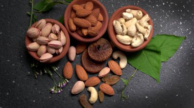 Stüdyo arka planında yeşil yapraklı çeşitli fındıklar.