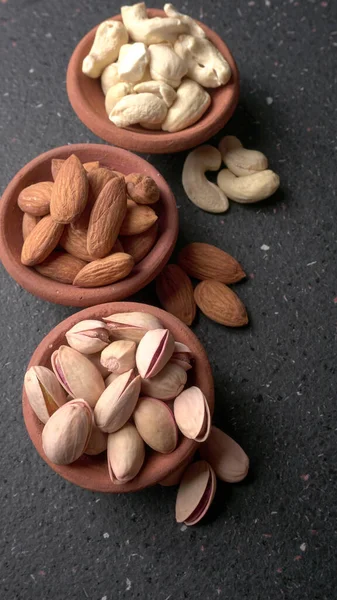 Stüdyo arka planında yeşil yapraklı çeşitli fındıklar.