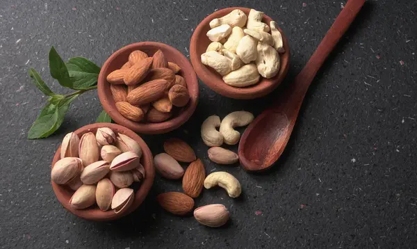 Stüdyo arka planında yeşil yapraklı çeşitli fındıklar.