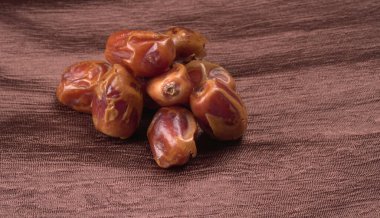 Masada kumaşlı hurma yığını var. Kurumuş meyveler, yakın çekim. 