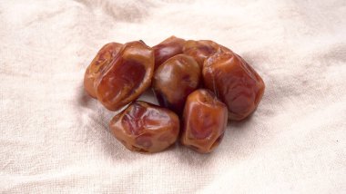 Masada kumaşlı hurma yığını var. Kurumuş meyveler, yakın çekim. 