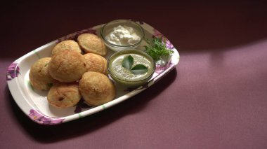 Lezzetli Hint atıştırmalıkları Punugulu yeşil Chutney sosuyla servis edilir. 