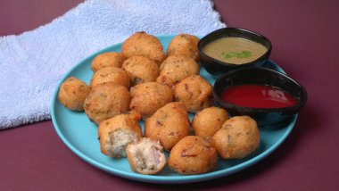 Lezzetli Hint atıştırmalıkları Punugulu, domates ve yeşil soslu bir tabakta servis ediliyor. 