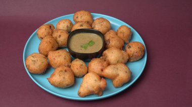 Lezzetli Hint atıştırmalıkları Punugulu yeşil Chutney sosuyla servis edilir. 