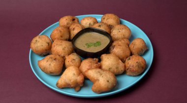 Lezzetli Hint atıştırmalıkları Punugulu yeşil Chutney sosuyla servis edilir. 